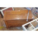 A 30" oak lift-top linen chest with panelled front, set on block feet