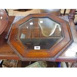 A 1920`s polished oak framed octagonal bevelled wall mirror