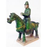 An 11" antique Chinese Ming style parade horseman decorated with jade green glaze and remains of