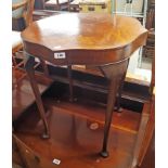 A 23 1/2" walnut quarter veneered serpentine topped occasional table, set on cabriole legs with