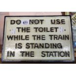 A reproduction cast metal train toilet sign