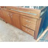 A 6' 3" modern teak effect sideboard with three drawers to one side and two cupboard doors, set on