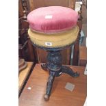 A late Victorian ebonised mahogany revolving piano stool with metal screw action and later studded