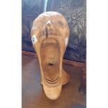 A carved wooden figure of a man screaming
