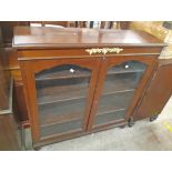 A 3' 6" late Victorian walnut and mixed wood book cabinet with adjustable shelves enclosed by a pair