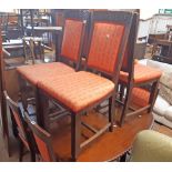A set of eight early 20th Century stained oak framed panel back dining chairs with carved top rails,