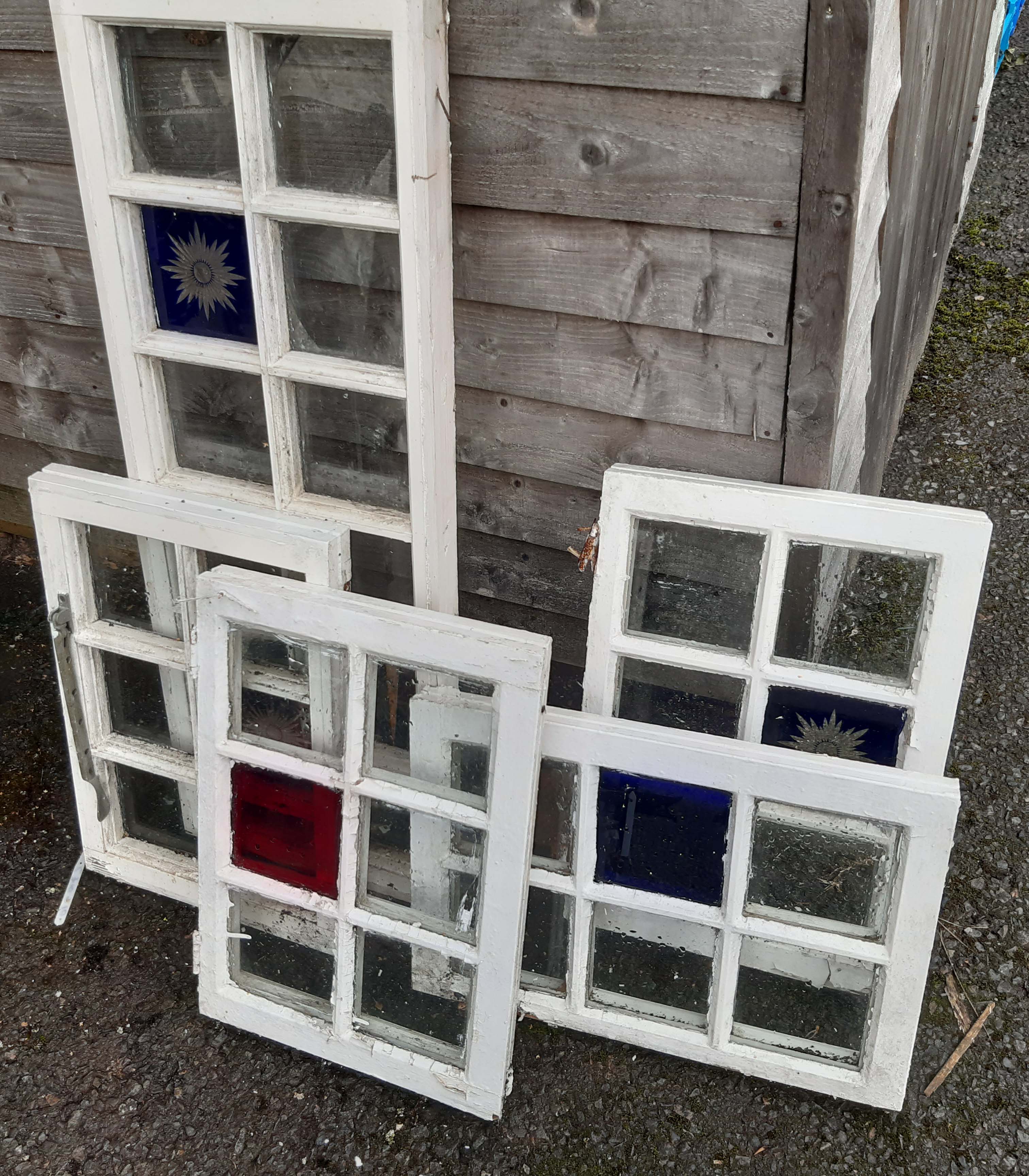 Five old casement windows, some with blue stained panels
