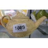 A 19th Century Wedgwood cane ware relief moulded teapot in the Rococo style with spaniel finial to