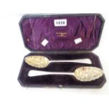 A Walker & Hall case containing a pair of Georgian Newcastle silver bright cut tablespoons with