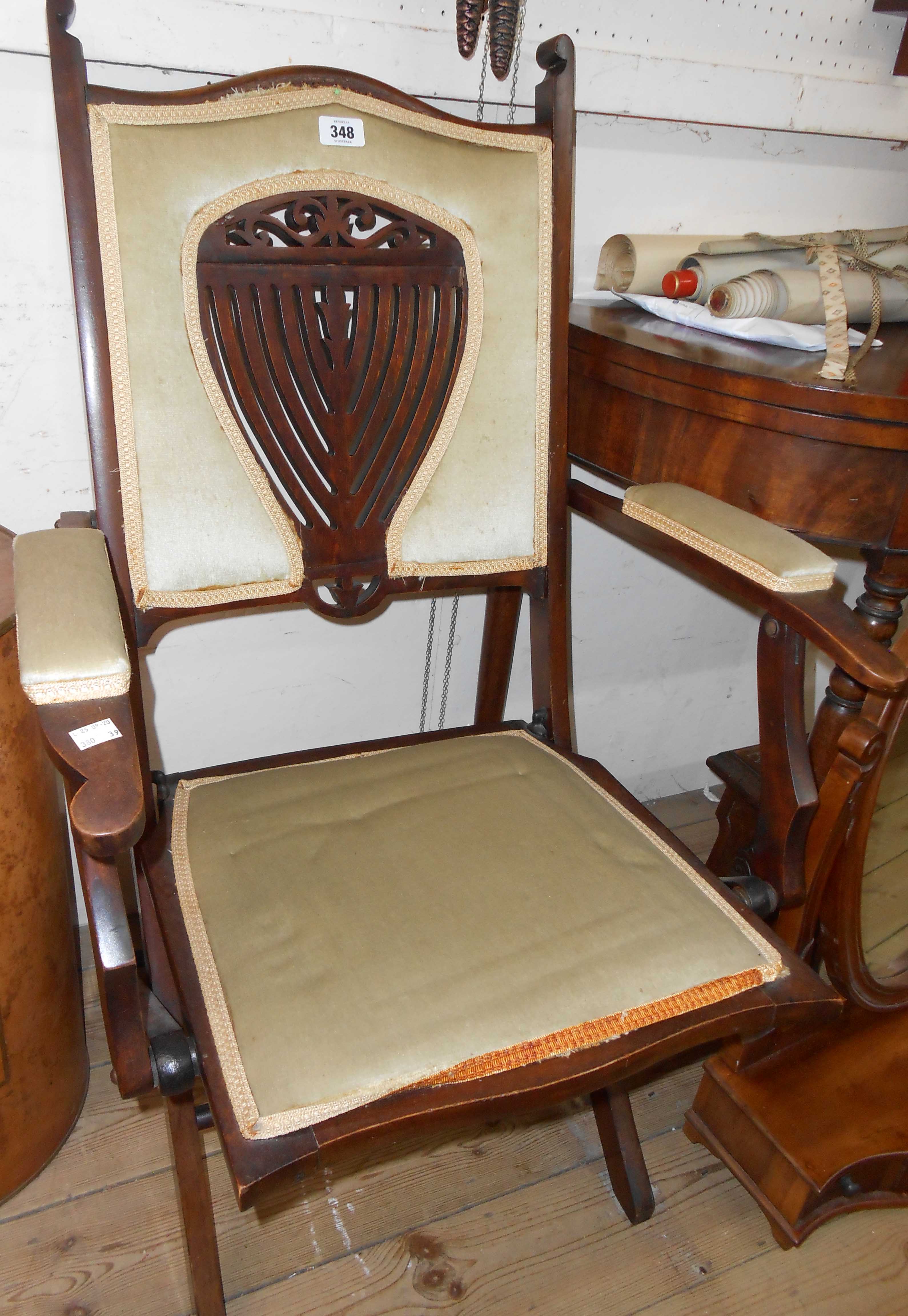 An Edwardian walnut framed campaign style folding chair with ornate pierced splat back and