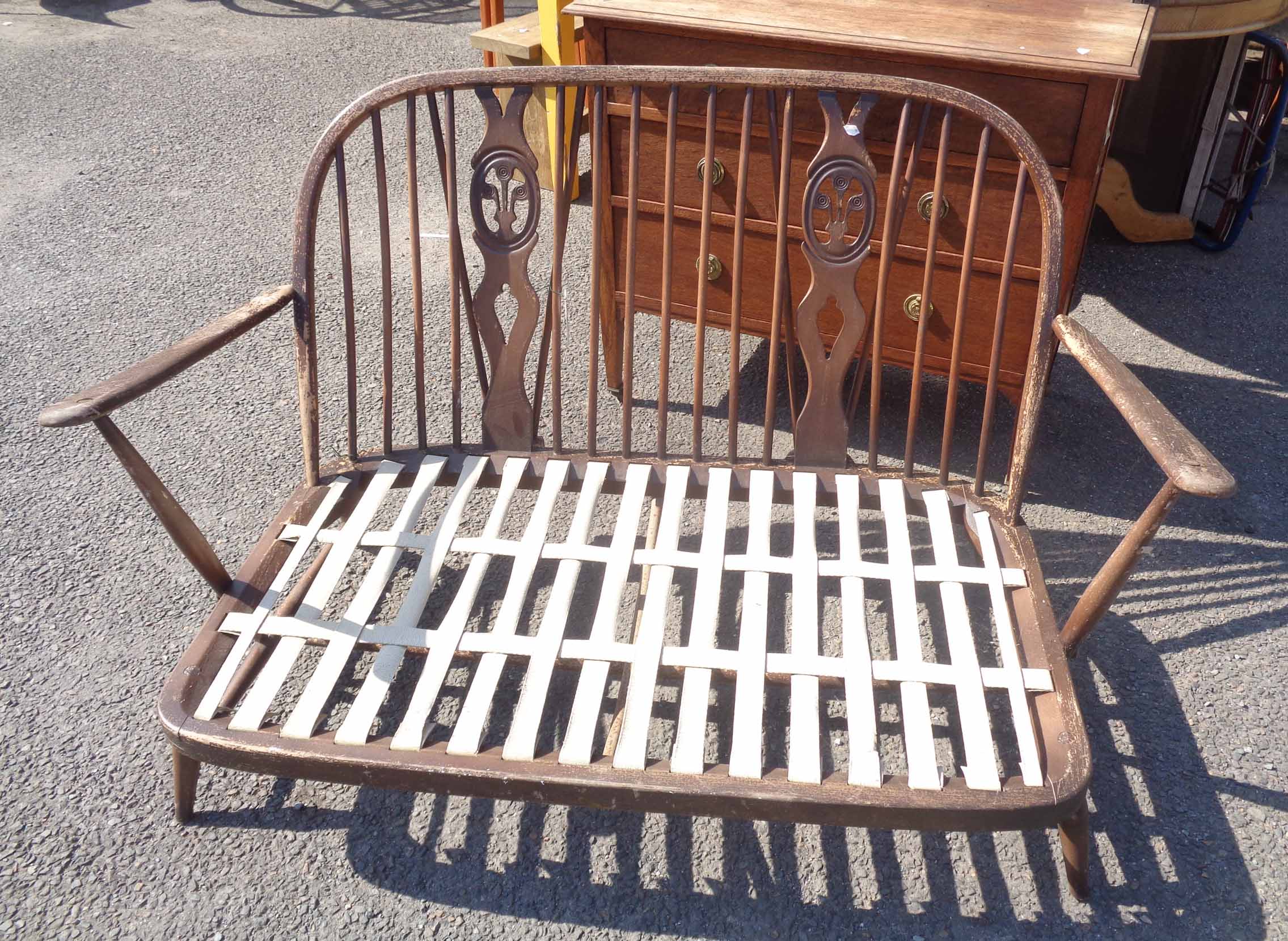 An Ercol dark elm settee frame - worn