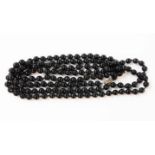 A 20th Century long string of black onyx beads