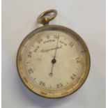 An antique brass pocket barometer with silvered dial
