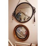 A wrought metal framed bevelled circular wall mirror with remains of braided tassel suspender - sold