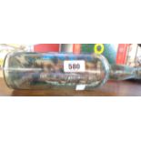 A vintage ship in a bottle diorama depicting a coastal town with windmill, church and lighthouse,