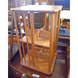 An Ercol style light elm revolving bookcase with two partitioned tiers and stick set sides - some