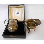 A cased Chester silver blank christening mug with cast scroll handle (two small dents) - sold with a