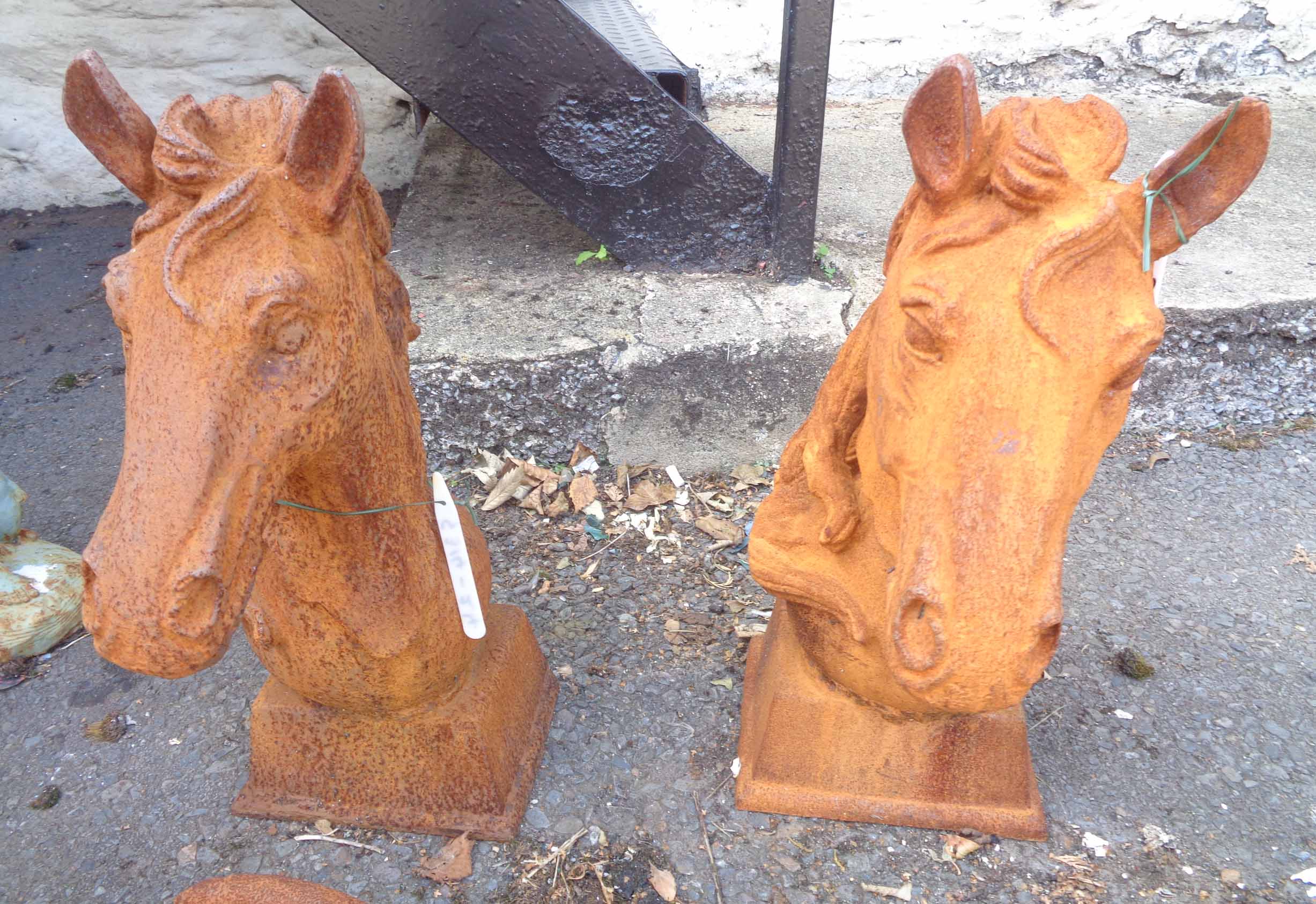 A pair of cast iron horse heads - 1 with A pair of cast iron horse heads - one with chip to base