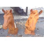 A pair of cast iron horse heads - 1 with A pair of cast iron horse heads - one with chip to base