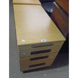 A 16 3/4" wood grain effect four drawer filing cabinet, set on casters