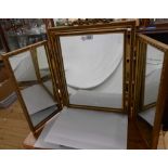 A vintage gilt framed triple dressing table mirror with bow pediment and later brass feet