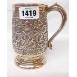 A 5 1/2" Anglo-Indian marked "sterling silver" tankard with embossed floral scroll decoration and