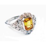 A marked PLAT Art Deco style ring, set with central oblong yellow sapphire within an diamond