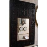 A heavy carved oak framed furniture panel style bevelled oblong wall mirror