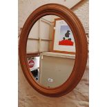 A modern moulded softwood framed oval wall mirror