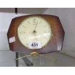 A vintage stained wood cased Smiths battery timepiece with associated Metamec movement