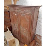 A 6' antique French heavily carved oak armoire, the adapted interior now with shelves enclosed by