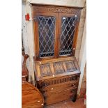 A 30" 20th Century polished oak bureau/bookcase with leaded glazed panel doors to top, part fitted