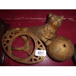 A vintage cast iron string holder in the form of a cat holding a ball with screw top for string