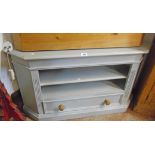 A 3' 8" 20th Century shabby chic grey painted wood corner media stand with two shelves and drawer