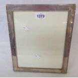 A modern Carrs Lustre silver fronted photograph frame with embossed border and polished wood easel
