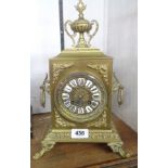 A late Victorian ornate cast brass cased mantle clock with urn pattern finial to top, flanking