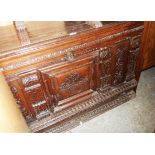 A 4' 5" antique French oak linen chest with lift-top extensive carved decoration to front, the