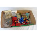 A box containing assorted toys including vintage Lego bricks, old marbles, five vintage card