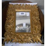 A small giltwood framed wall mirror with carved vine pattern border