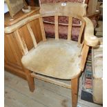 An old bleached wood smoker's bow elbow chair with solid elm moulded seat, set on square supports