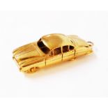 A hallmarked 9ct. gold charm in the form of a jaguar mark 10 automobile by QK Ltd.