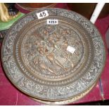 An Indian plate dish, a heavy copper plaque with relief decoration, and three further examples