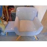 A retro style low armchair with button back grey upholstery, set on polished wood splayed legs -