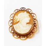 A marked 18ct yellow metal open scroll framed oval cameo brooch - cracks to shell
