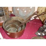 A set of three graduated antique copper saucepans with iron handles