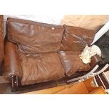 A 6' 6" 20th Century two seater settee upholstered in studded brown leather, set on turned front