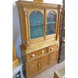 A 3' 10" antique waxed pine two part Irish dresser with break front cornice and pair of arched