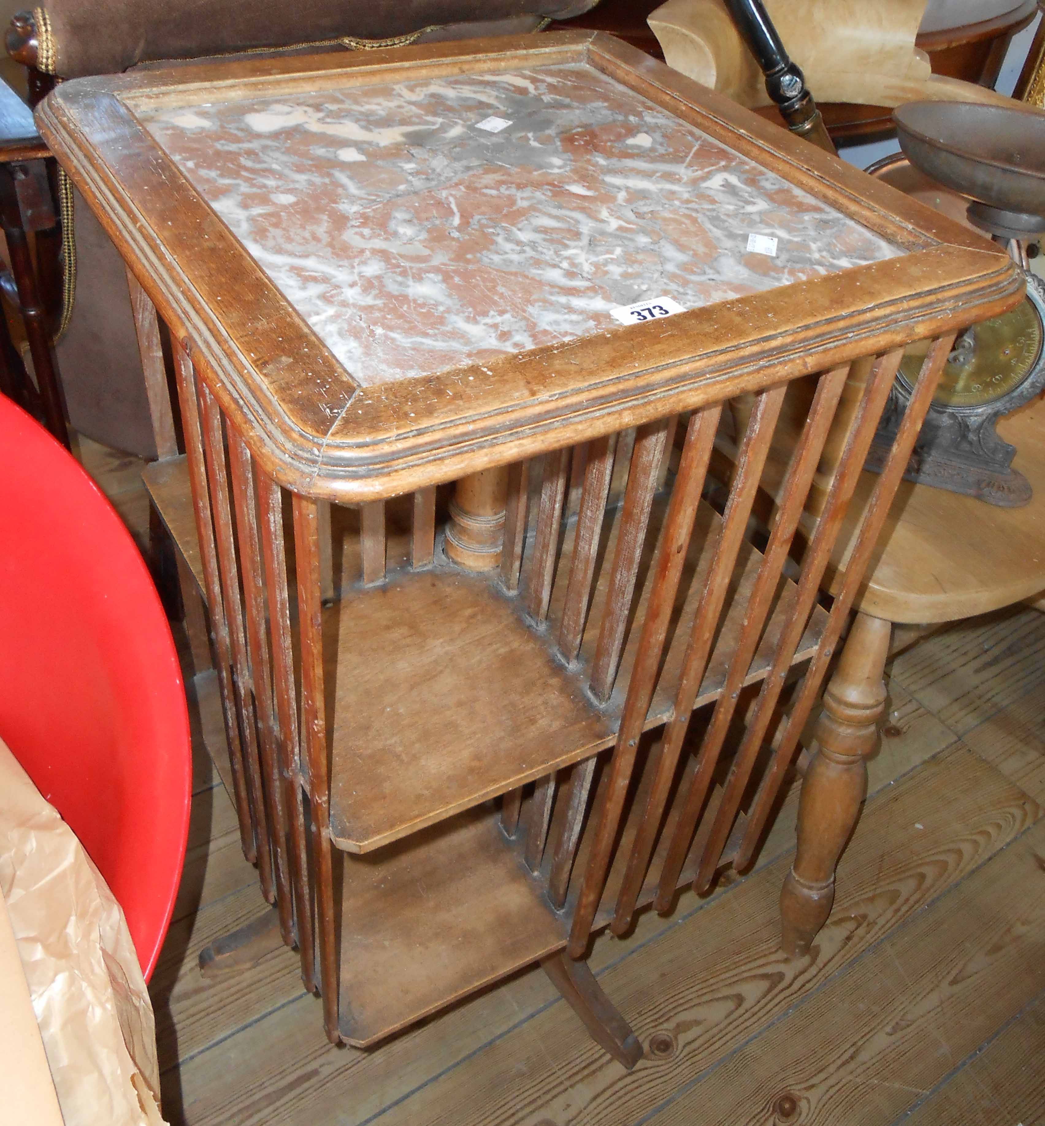 A French stained mixed wood revolving bookcase with marble inset top and slatted dividers - old worm