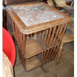 A French stained mixed wood revolving bookcase with marble inset top and slatted dividers - old worm