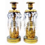 A pair of 19th Century ormolu candlesticks with grapevine decoration and repeat acanthus banding,